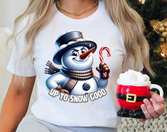 May include: White t-shirt with a cartoon snowman wearing a brown scarf and holding a candy cane. The text "Up to snow good" is printed below the snowman.