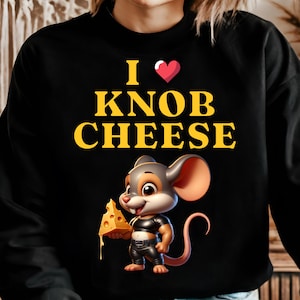 Puede incluir: Sudadera negra con un gráfico de un ratón sosteniendo un trozo de queso. El texto "I ♥ KNOB CHEESE" está impreso en amarillo en la camiseta.