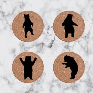 May include: Four cork coasters with black bear silhouettes. Each coaster features a different bear pose.