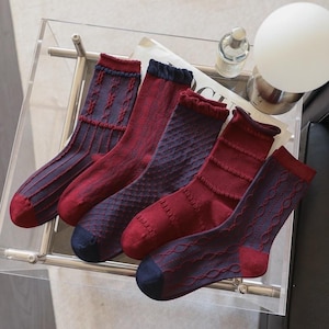 Könnte beinhalten: Fünf Paar Socken in verschiedenen Farben von Dunkelblau und Burgunderrot mit unterschiedlichen Mustern. Die Socken sind aus einem weichen, bequemen Material gefertigt und perfekt für den Alltag.