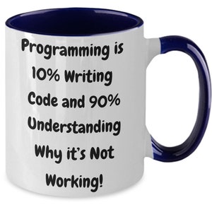 Puede incluir: Taza de café de cerámica blanca con borde y asa azules. La taza tiene texto negro que dice "Programming is 10% Writing Code and 90% Understanding Why it's Not Working!"