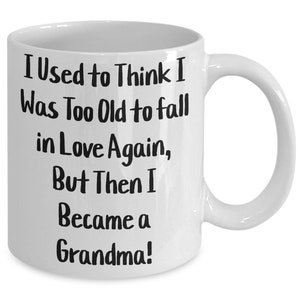 May include: White ceramic coffee mug with black text that reads "I Used to Think I Was Too Old to Fall in Love Again, But Then I Became a Grandma!"