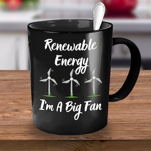 Può includere: Tazza da caffè nera con testo bianco che recita "Energia rinnovabile Sono un grande fan" e tre turbine eoliche dei cartoni animati.