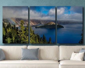 May include: A three-panel canvas print of a lake with a small island in the middle. The lake is surrounded by trees and mountains. The sky is blue with white clouds. The print is 36 inches wide and 72 inches tall.
