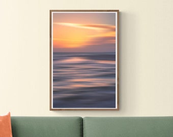 May include: A green sofa with a light orange throw pillow in front of a wall with a framed photograph of a sunset over the ocean. The text "24x36" is in the upper right corner of the image.
