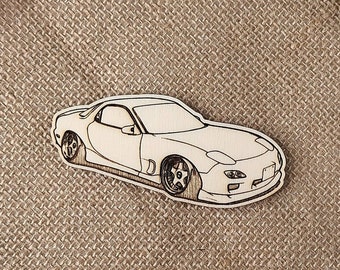 May include: A white wooden cutout of a sports car on a brown burlap background.