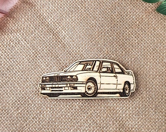 May include: A white wooden cutout of a classic car, possibly a BMW, on a burlap background.