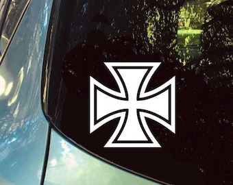以下が含まれることがあります： 銀色の車のリアウィンドウに貼られた白い鉄製の十字架のステッカー