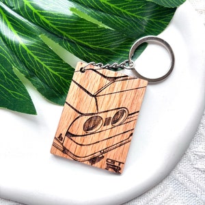 May include: A wooden keychain with a laser-engraved image of a car's rear end. The keychain features the text "GT-R" on the bottom.