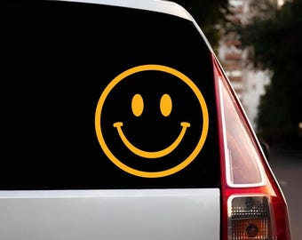 May include: A yellow smiley face sticker on a black car.