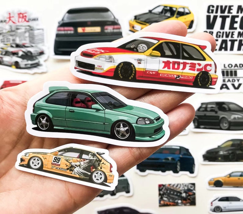 May include: A collection of colorful car stickers featuring Honda Civics. The stickers are printed on white paper and feature different designs, including a green Civic, a yellow Civic with the number 99, and a red Civic with Japanese text.