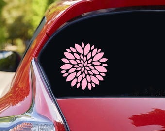 以下が含まれることがあります： 赤い車のピンクの花のステッカー。花はスタイリッシュで円形です。