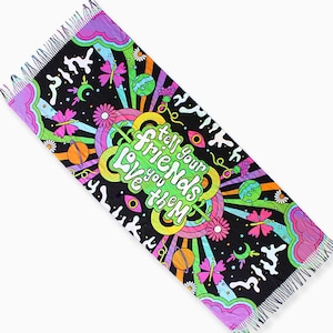 May include: A black and colorful tapestry with a fringed edge. The tapestry features a psychedelic design with planets, stars, butterflies, and flowers. The text "Tell your friends Love you them" is written in a colorful, whimsical font.
