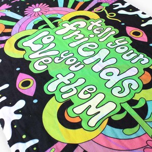May include: A black fabric tapestry with a psychedelic design featuring a green, yellow, and white text that reads "Tell your friends you love them".