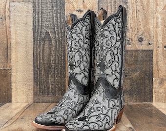 May include: A pair of black leather cowboy boots with silver embroidery and rhinestones. The boots have a pointed toe and a high heel.
