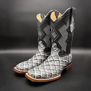 May include: A pair of black leather cowboy boots with a grey diamond pattern. The boots have a pointed toe and a low heel.