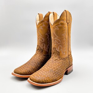 May include: A pair of brown leather cowboy boots with a woven pattern. The boots have a pointed toe and a low heel.