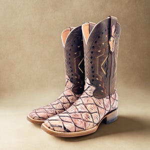 May include: A pair of cowboy boots with a brown and pink scale-like pattern on the foot and a brown shaft with decorative stitching. The boots have a square toe and a stacked heel, perfect for Western wear.
