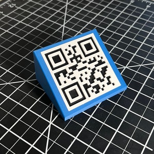 May include: A blue plastic stand with a white QR code printed on the top.