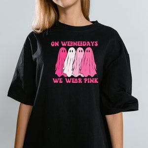 May include: Black t-shirt with a pink graphic of three ghosts and the text "On Wednesdays We Wear Pink."
