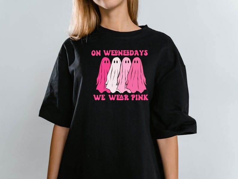 May include: Black t-shirt with a pink graphic of three ghosts and the text "On Wednesdays We Wear Pink."
