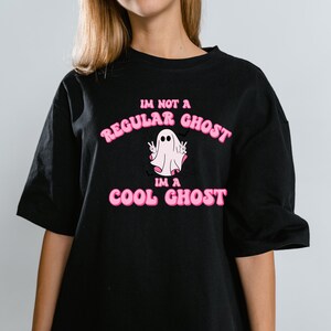 May include: Black t-shirt with a pink graphic of a ghost with the text "I'm not a regular ghost, I'm a cool ghost."