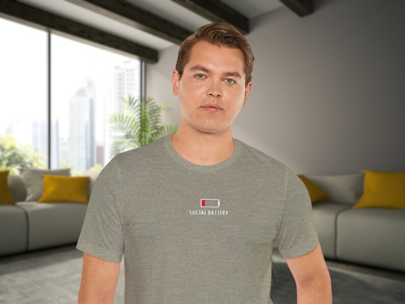 Op de afbeelding: Een heidegrijs T-shirt met een witte afbeelding van een bijna lege batterij en de tekst "Social Battery".