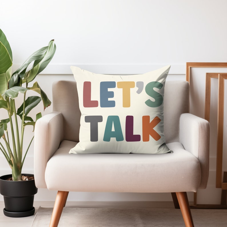 May include: A white throw pillow with the text "LET'S TALK" in colorful block letters. The letters are in shades of red, blue, yellow, gray, teal, purple, and orange.