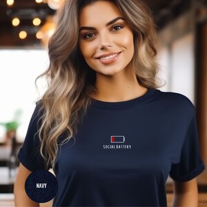 Op de afbeelding: Een marineblauw t-shirt met een witte afbeelding van een bijna lege batterij en de tekst "Social Battery".