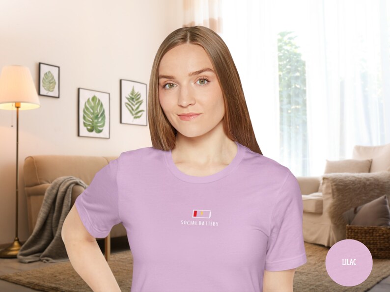 Op de afbeelding: Een lila t-shirt met een witte afbeelding van een bijna lege batterij en de tekst "Social Battery".