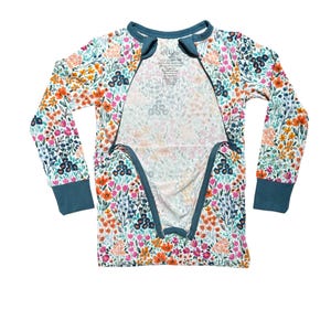 K&ouml;nnte beinhalten: Ein Schlafanzug-Set mit floralem Print und langen &Auml;rmeln mit t&uuml;rkisfarbenem Besatz. Der Schlafanzug hat ein farbenfrohes Muster aus Blumen in Orange-, Rosa- und Blaut&ouml;nen auf wei&szlig;em Hintergrund. Das Set hat einen Rei&szlig;verschluss vorne.