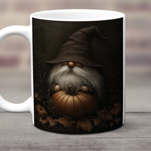 May include: White ceramic mug with a dark brown background featuring a gnome holding a large orange pumpkin. The gnome is wearing a brown pointed hat and has a white beard.