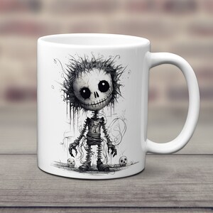 May include: White ceramic coffee mug with a black and white illustration of a cartoon skeleton with a stitched-up body and a creepy smile. The skeleton is surrounded by skulls.