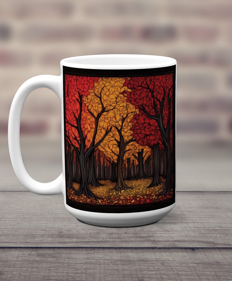 K&ouml;nnte beinhalten: Wei&szlig;e Keramiktasse mit einer farbenfrohen Illustration einer Waldszene. Die B&auml;ume sind stilisiert und haben rote, orange und gelbe Bl&auml;tter. Der Hintergrund ist schwarz.