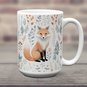 May include: White ceramic mug with a fox illustration surrounded by a pattern of stylized leaves and flowers in shades of green, brown, and white.