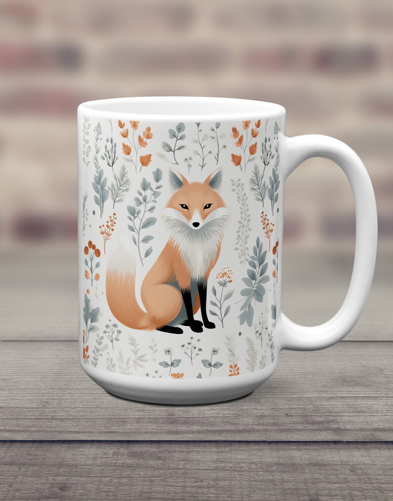 May include: White ceramic mug with a fox illustration surrounded by a pattern of stylized leaves and flowers in shades of green, brown, and white.