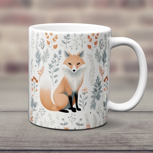 May include: White ceramic mug with a fox illustration surrounded by a floral pattern in shades of orange, blue, and green.