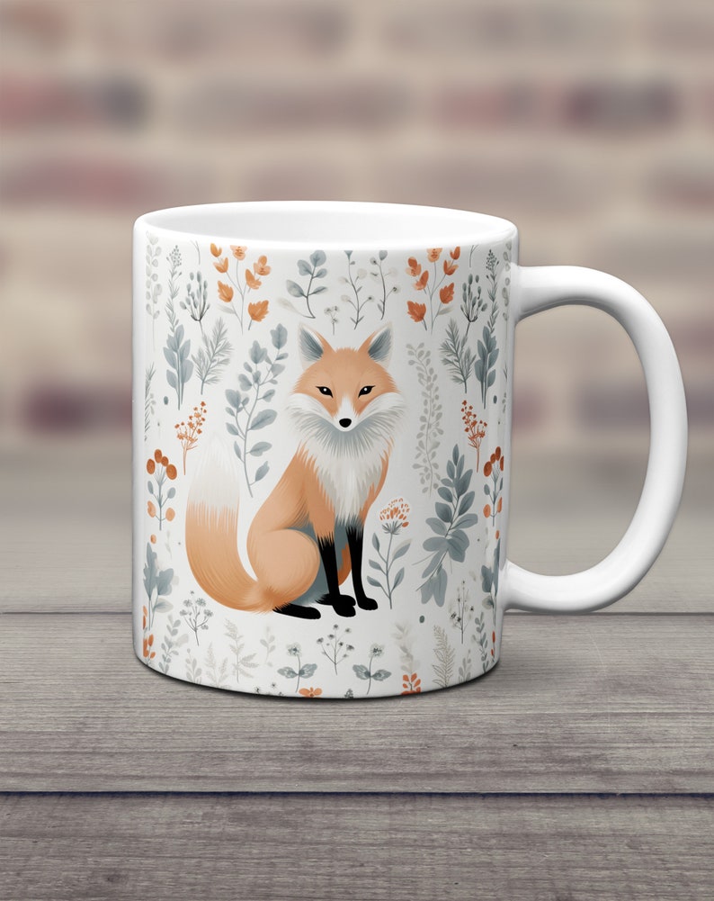 May include: White ceramic mug with a fox illustration surrounded by a floral pattern in shades of orange, blue, and green.