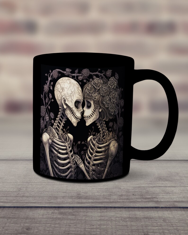 May include: Black coffee mug with a white and gray illustration of two skeletons embracing. The skeletons are surrounded by roses and vines.