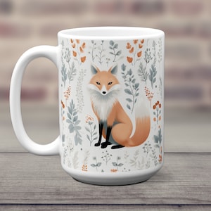 May include: White ceramic mug with a fox illustration surrounded by a pattern of stylized leaves and flowers in shades of gray, brown, and orange.