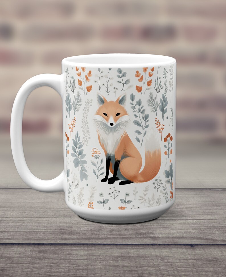 May include: White ceramic mug with a fox illustration surrounded by a pattern of stylized leaves and flowers in shades of gray, brown, and orange.