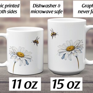 May include: Two white ceramic mugs with a daisy and bee design. The mug on the left is 11 ounces and the mug on the right is 15 ounces. Both mugs are dishwasher and microwave safe. The graphic is printed on both sides and will not fade.