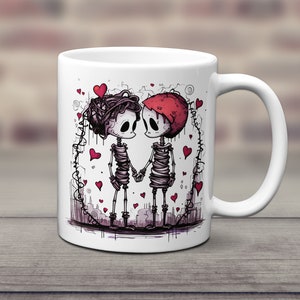 May include: White ceramic mug with a graphic of two skeletons holding hands. The skeletons are wrapped in bandages and have red hearts around them. The mug is a great gift for couples.