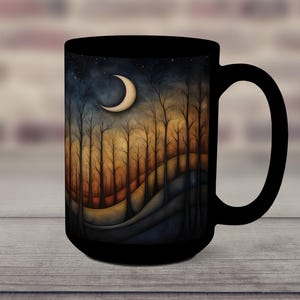 May include: Black ceramic mug with a crescent moon and forest scene design. The scene features a dark blue sky with stars, a crescent moon, and a forest of trees with orange and brown leaves. The background is a dark blue and purple gradient.