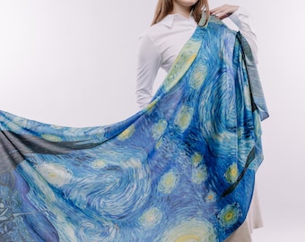 May include: A woman wearing a white shirt and a blue and yellow scarf with a swirling pattern. The scarf features a painting of a starry night sky.