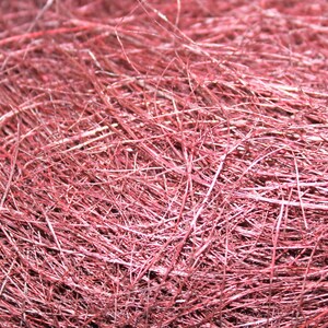 May include: A close-up of a pile of pink shredded paper, commonly used for gift wrapping and packaging.