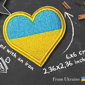 May include: A heart-shaped embroidered patch with the colors of the Ukrainian flag, blue and yellow. The patch is 6x6 cm or 2.36x2.36 inches. The text "Glued with an iron" and "From Ukraine" is written on the black background.