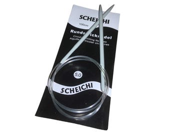 May include: A pair of light gray circular knitting needles with a clear plastic cable, size 5.0, on a black and white Scheichi package. The package reads "100cm" and "Circular Knitting Needles."