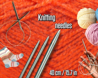May include: Image features knitting needles, yarn, and a pair of knitted socks. The text "Knitting needles" is displayed. The needles are 15.7 inches (40 cm) long. The background is orange yarn.