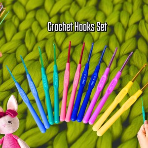 May include: A set of colorful crochet hooks with ergonomic handles in various sizes. The hooks are arranged on a green textured background, with the text "Crochet Hooks Set" displayed above. The hooks are in shades of blue, green, pink, and yellow.